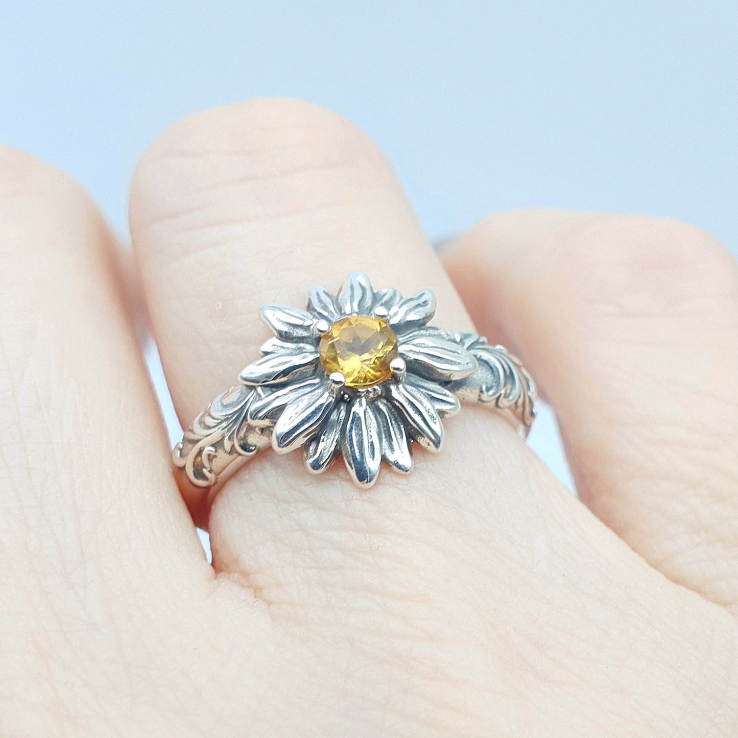 Anello in argento 925 con girasole e quarzo citrino taglio brillante, decorazioni barocche ai lati.