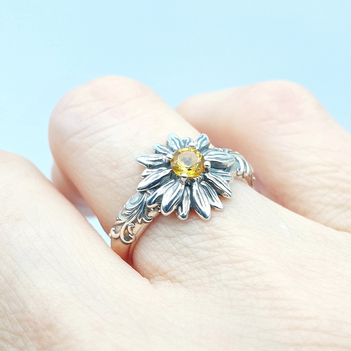 Anello in argento 925 con girasole e quarzo citrino taglio brillante, decorazioni barocche ai lati.