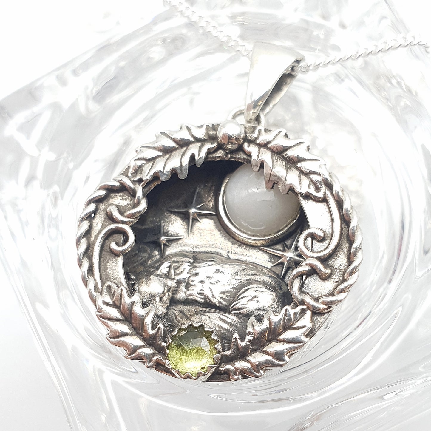 Ciondolo incassato in argento 925 con labradorite bianca e peridoto, raffigura una volpe che dorme sotto un cielo stellato, avvolta in decorazioni di foglie di quercia e riccioli.