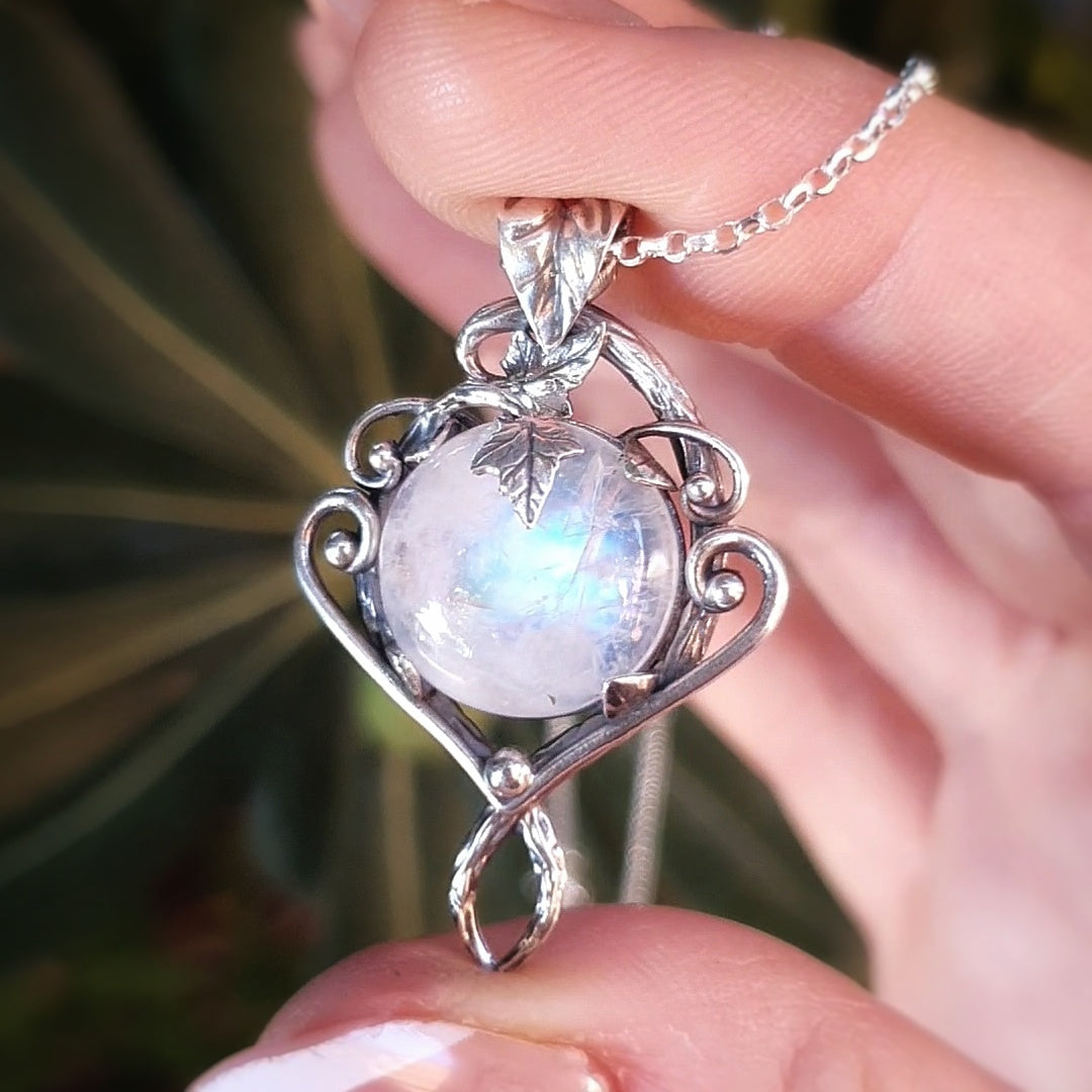 Ciondolo in argento con motivi di rametti e fili lisci, labradorite bianca rotonda e foglie d'edera.
