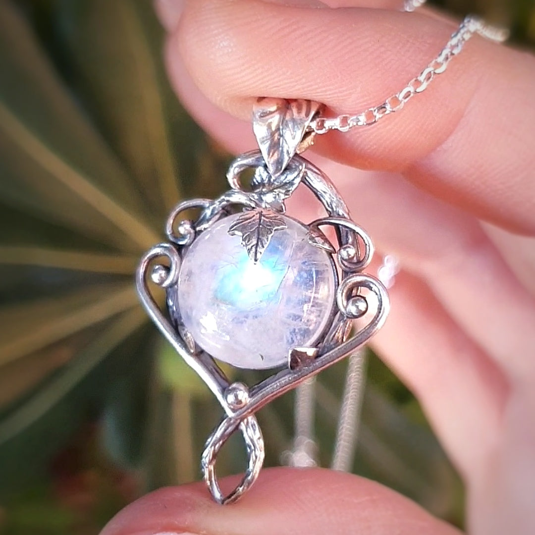 Ciondolo in argento con motivi di rametti e fili lisci, labradorite bianca rotonda e foglie d'edera.