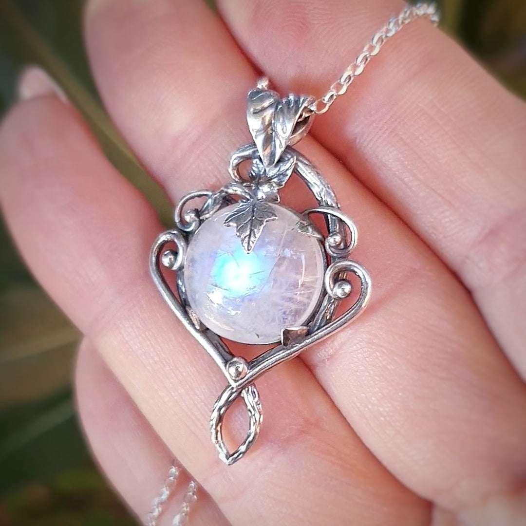 Ciondolo in argento con motivi di rametti e fili lisci, labradorite bianca rotonda e foglie d'edera.