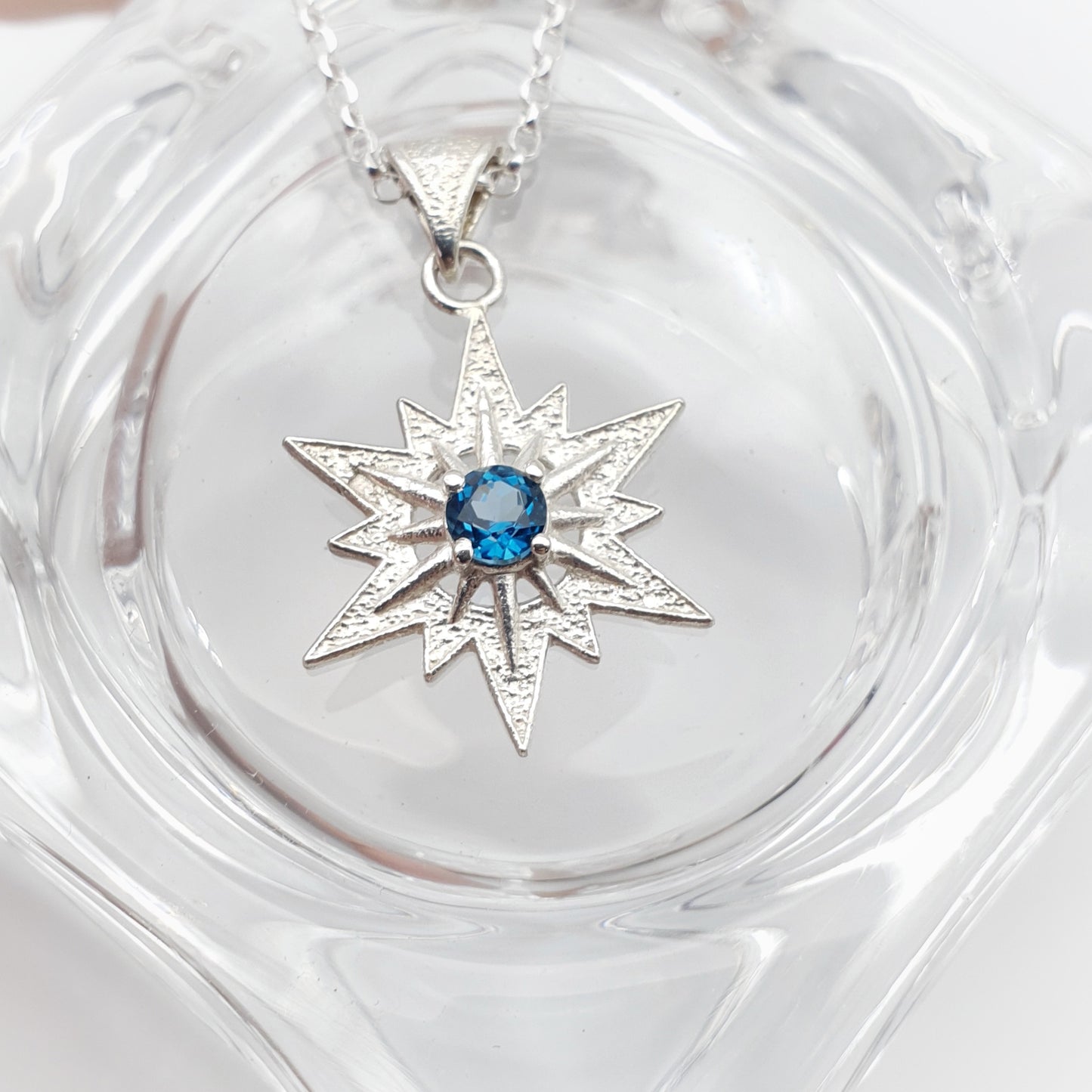 Ciondolo in argento 925 raffigurante la stella di Betlemme, con topazio blu london taglio brillante.