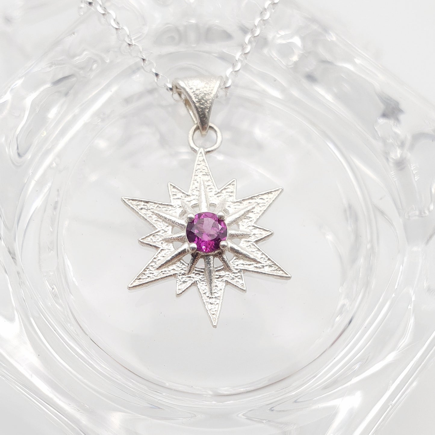 Ciondolo in argento 925 raffigurante la stella di Betlemme, con rodolite taglio brillante.