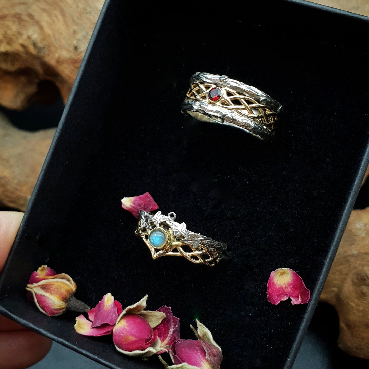 Coppia di fedi in argento e oro 14kt con labradorite e granato, inseriti in una scatolina adorna di boccioli di rosa.