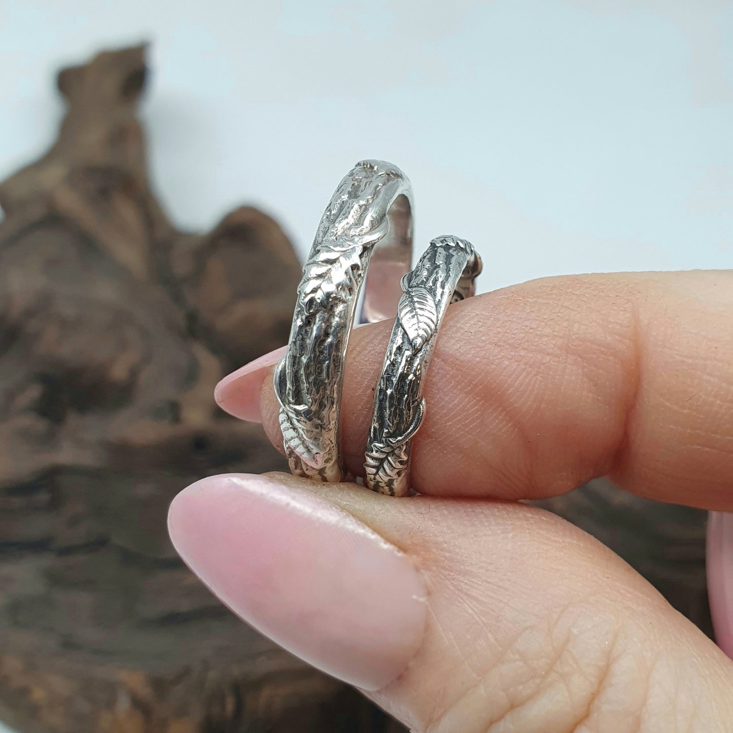 Fedi in argento con texture corteccia, foglie di quercia e di frassino si alternano lungo la circonferenza.