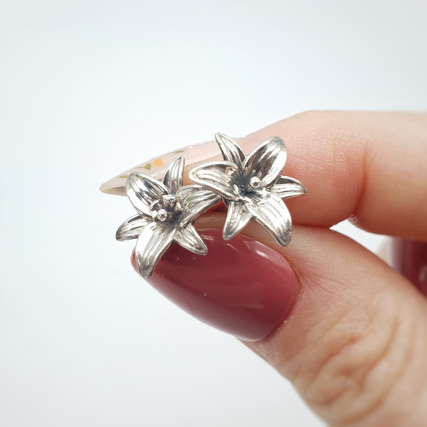 Coppia di orecchini a perno in argento 925, raffiguranti un fiore di giglio.