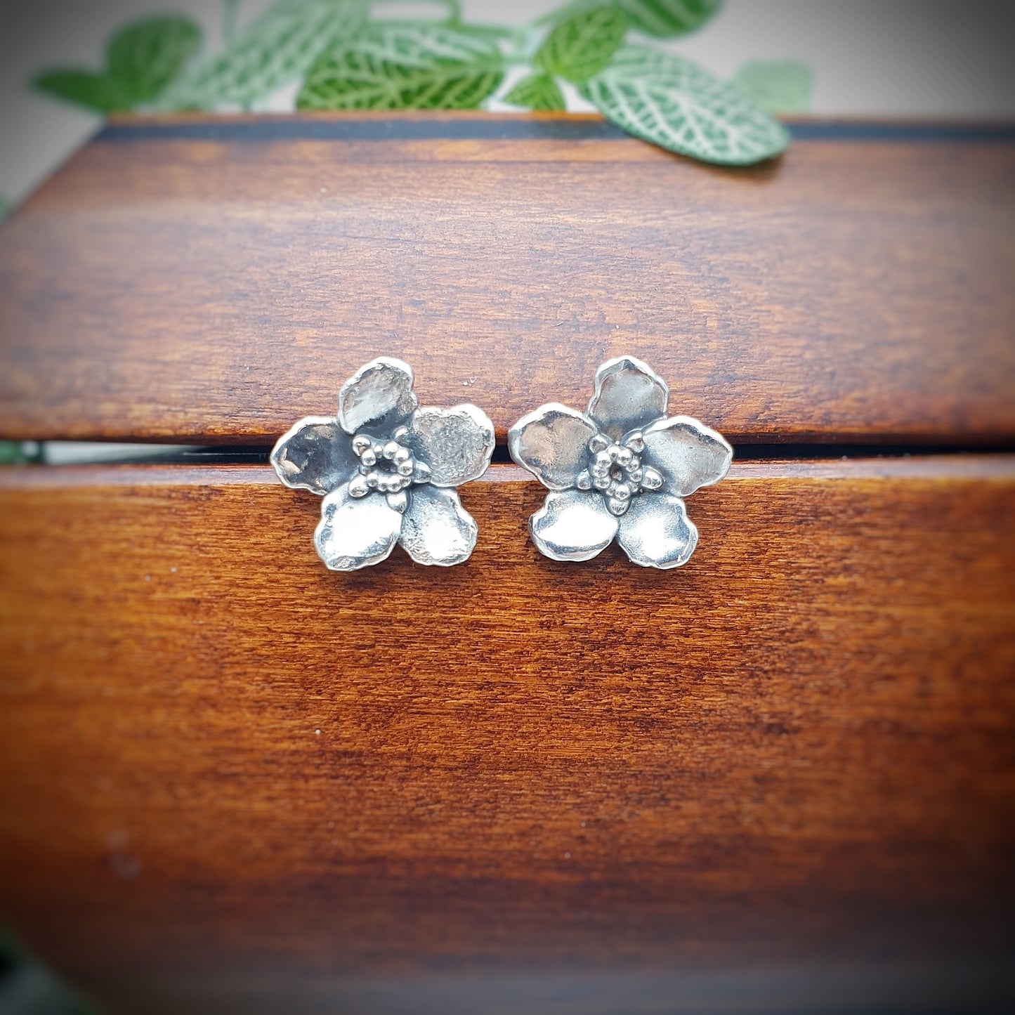 Coppia di orecchini a perno in argento 925, raffiguranti un fiore di myosotis.