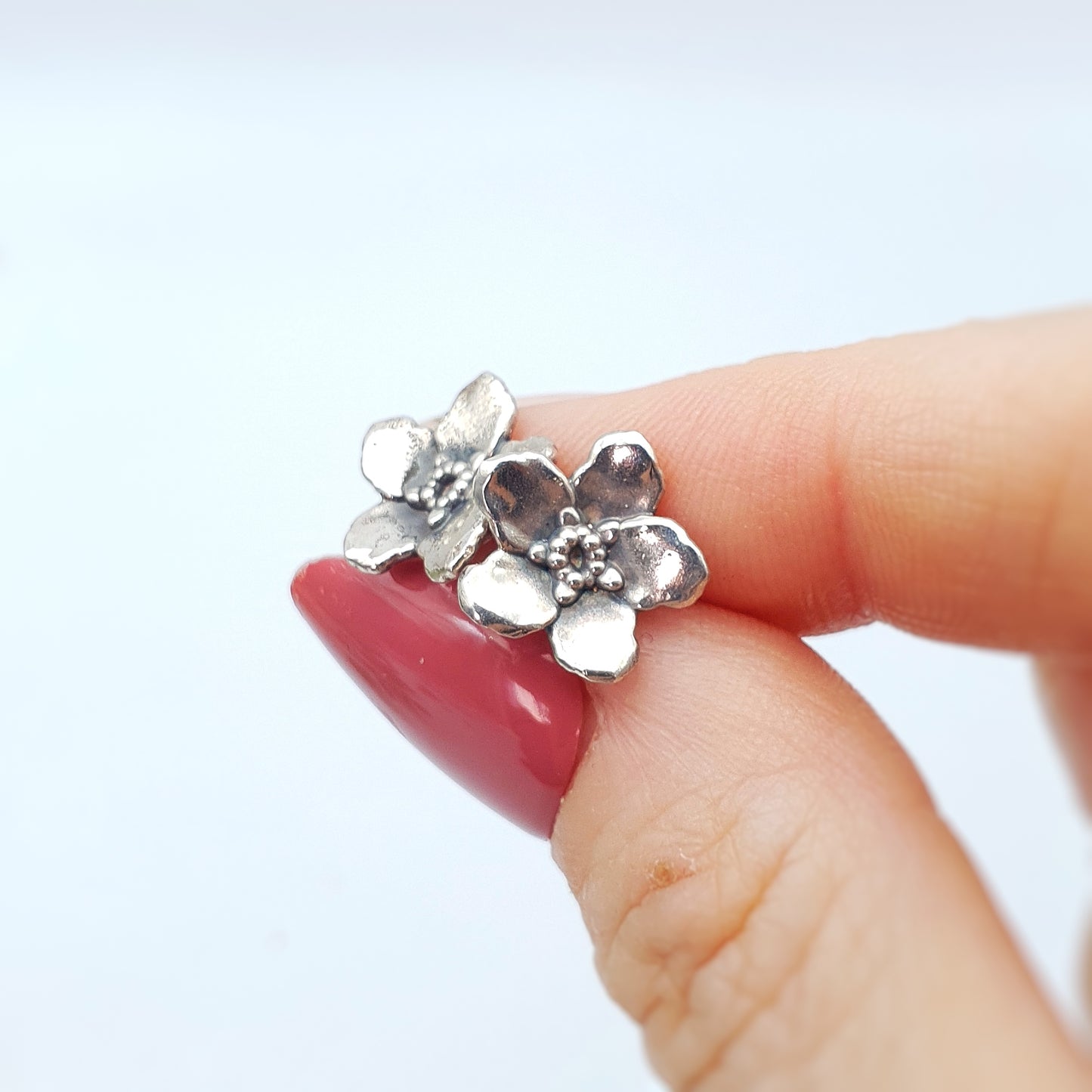 Coppia di orecchini a perno in argento 925, raffiguranti un fiore di myosotis.