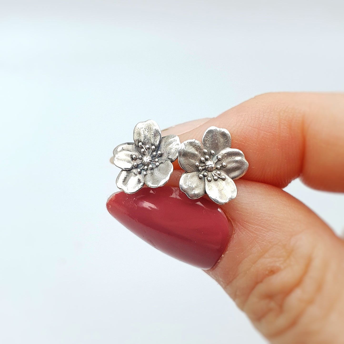 Coppia di orecchini a perno in argento 925, raffiguranti un fiore di rosa canina.