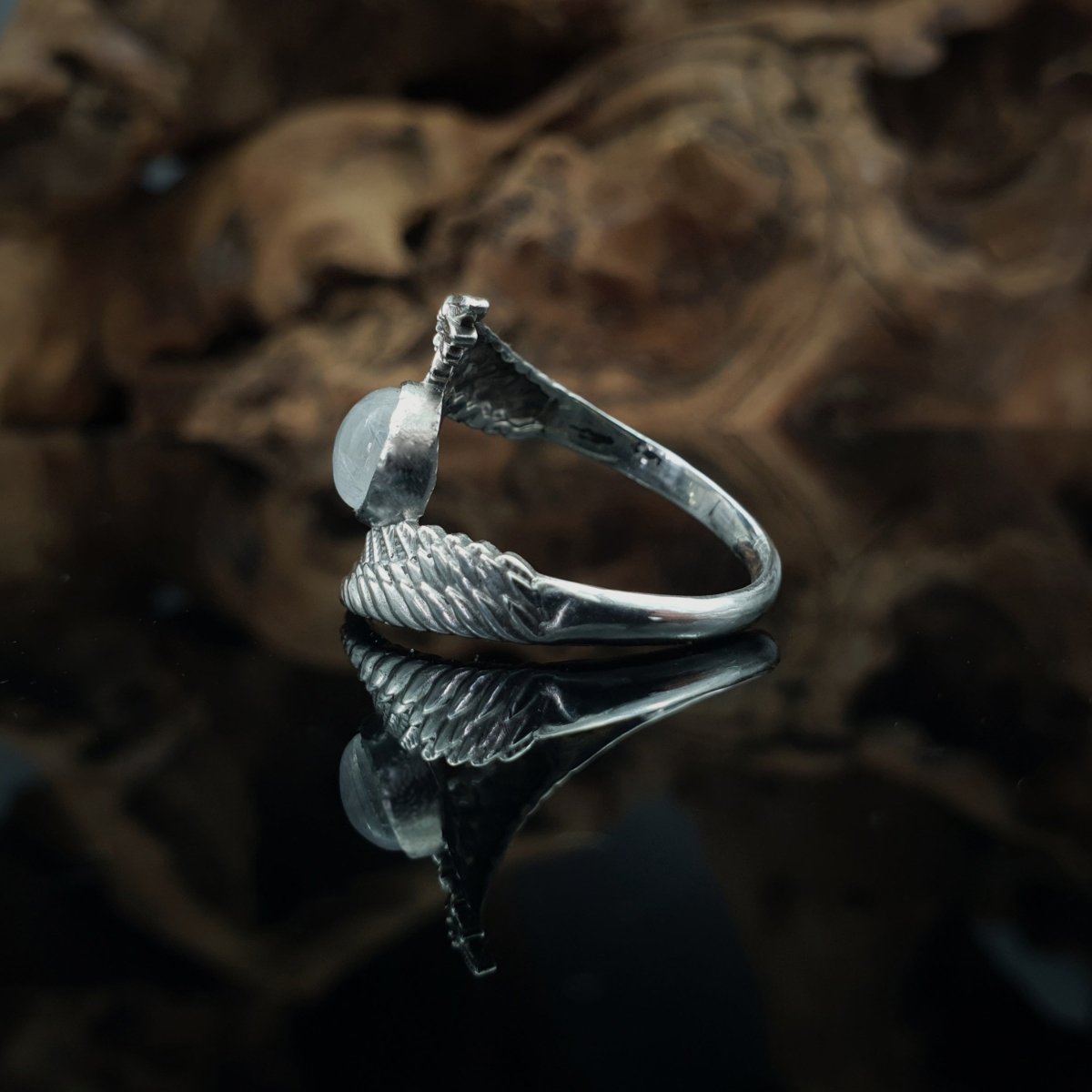 Anello in argento 925, due ali abbracciano un cabochon rotondo di labradorite bianca.