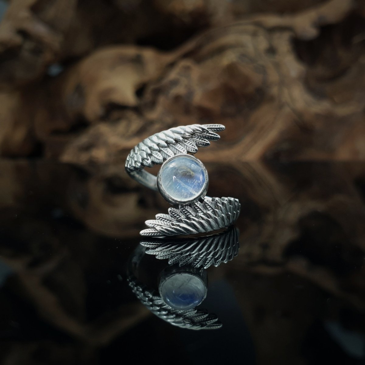 Anello in argento 925, due ali abbracciano un cabochon rotondo di labradorite bianca.