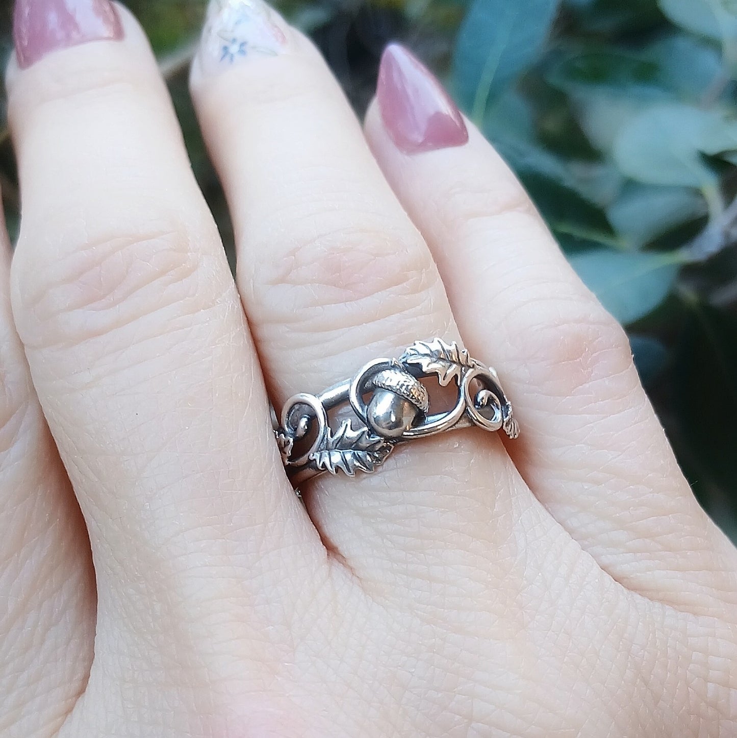 Anello in argento 925 raffigurante una ghianda, ornata da foglie di quercia fili decorativi.