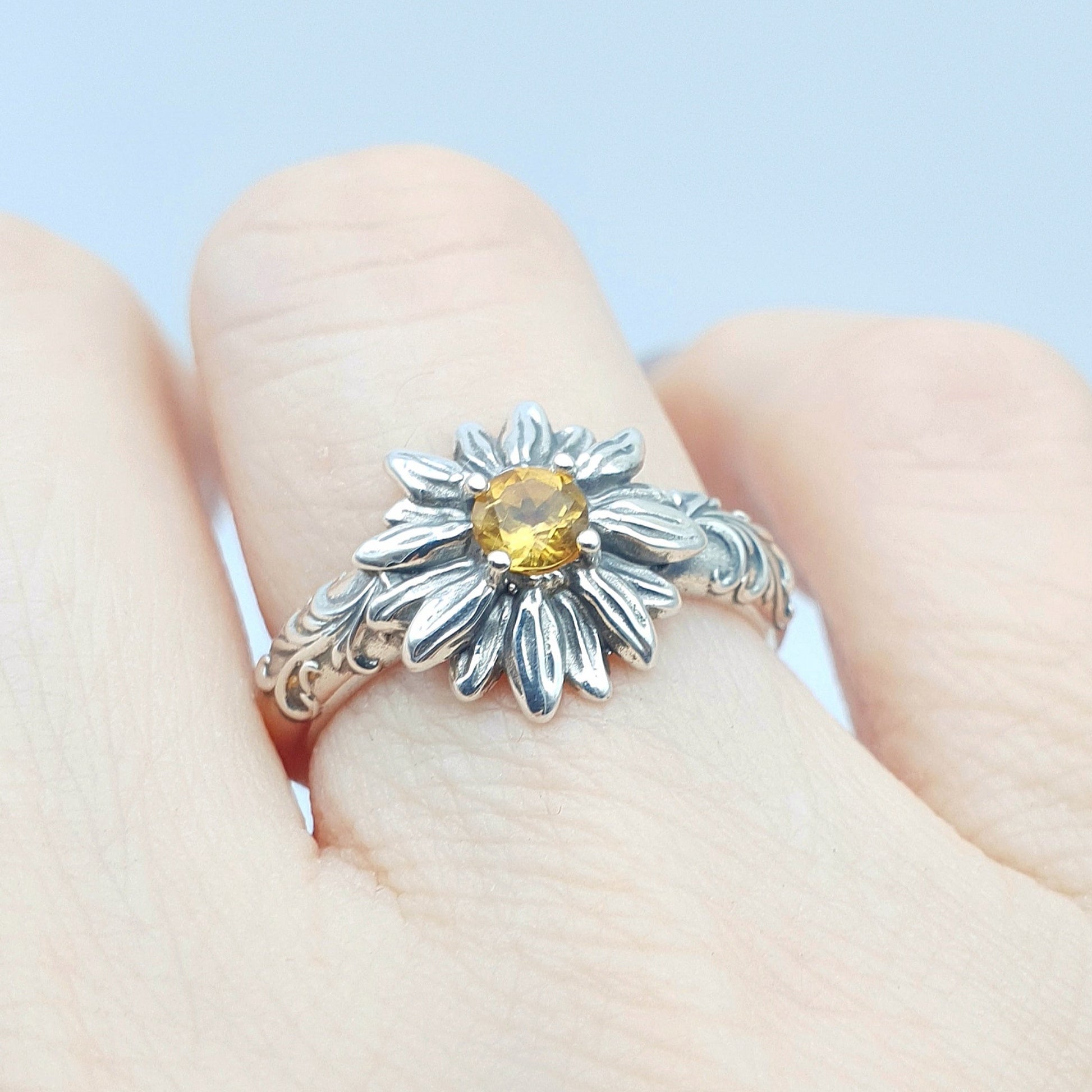 Anello in argento 925 con girasole e quarzo citrino taglio brillante, decorazioni barocche ai lati.