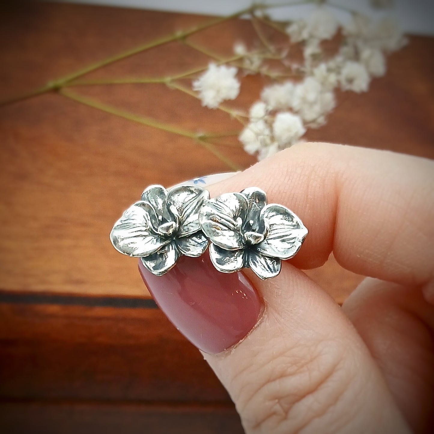 Coppia di orecchini a perno in argento 925 raffiguranti il fiore di orchidea.