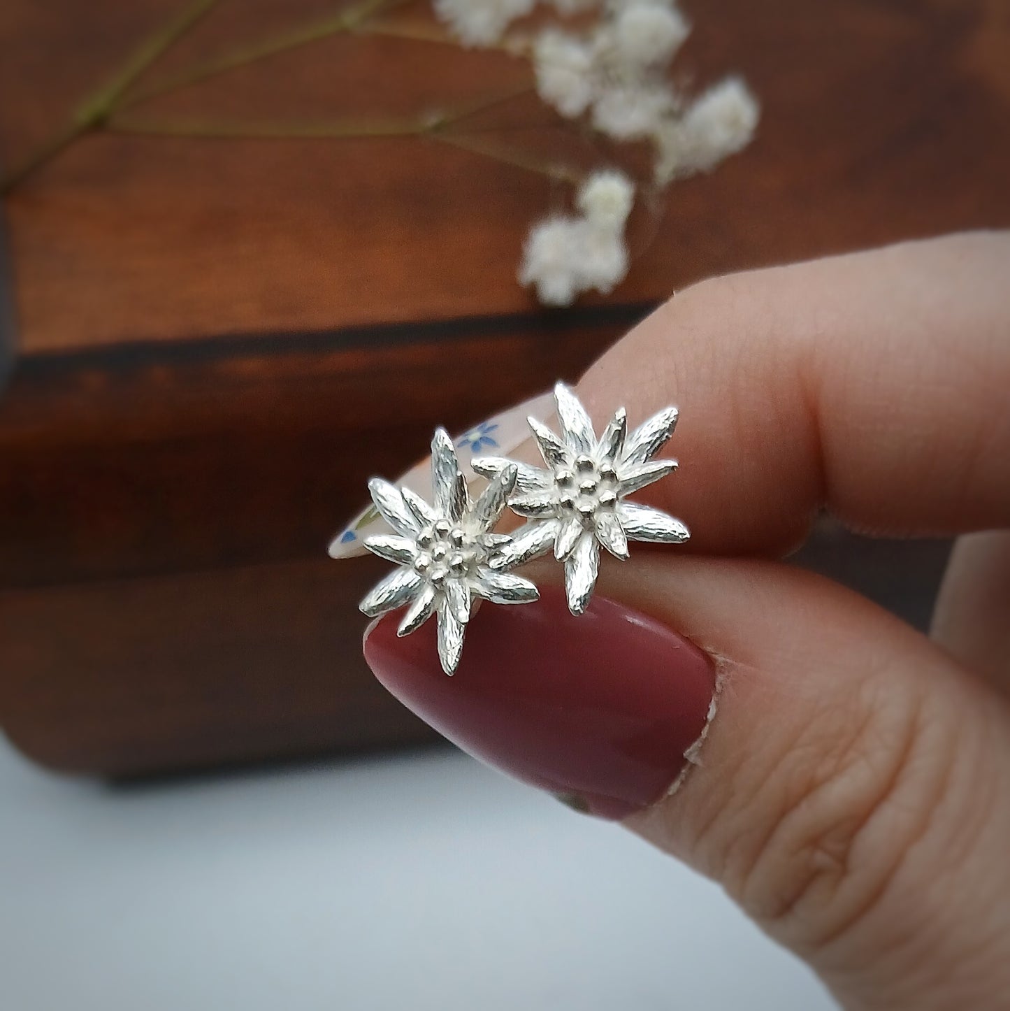 Coppia di orecchini in argento 925 raffiguranti un fiore di stella alpina.